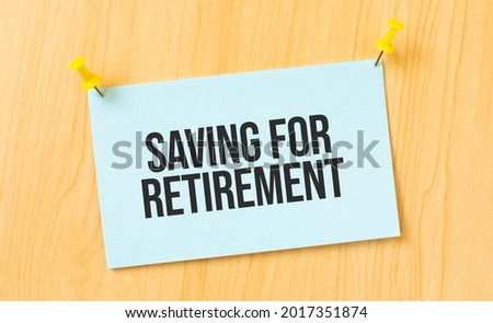 Saving For Retirement sign written on sticky note pinned on wooden wall