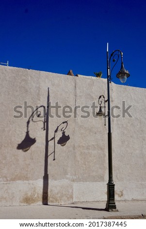 Ornate lamp post shadow on wall