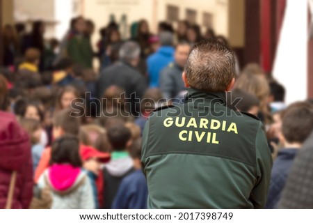 A Spanish civil guard watches a peaceful manifestation Royalty-Free Stock Photo #2017398749