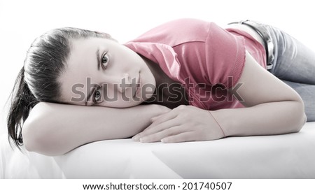 Studio shot of an attractive model lying on one side. This photo is isolated on white background with copy paste
