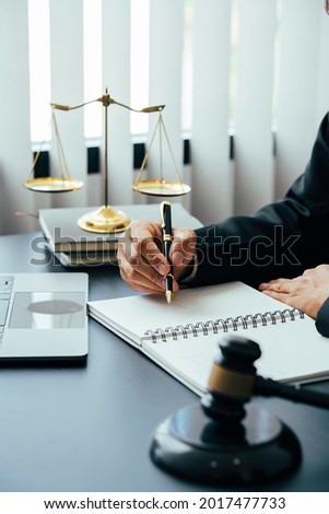 justice and law concept. the judge in a courtroom with the gavel, male judge with writing documents on the table in office, closeup