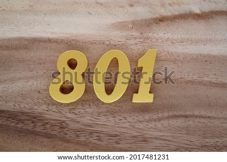 Golden Arabic 801 numerals on a brown to white patterned wooden background.