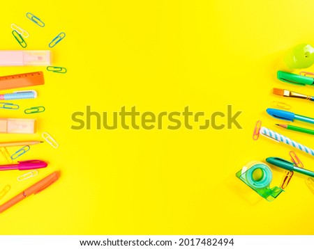 Back to school concept. Colorful stationery writing tools frame on yellow background. Office supply accessories