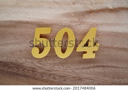 Golden Arabic 504 numerals on a brown to white patterned wooden background.