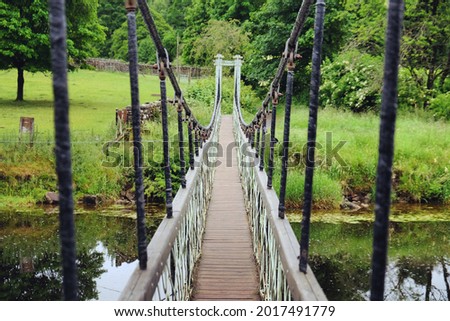 Hebden Suspension Bridge over the River Wharfe, in the Yorkshire Dales, North Yorkshire. Royalty-Free Stock Photo #2017491779