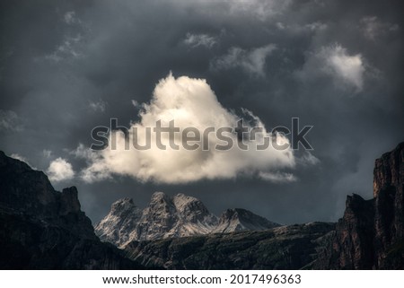 White cloud illuminated by the sun over the top of the mountains during the storm
