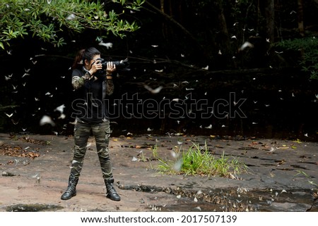Professional woman photographer taking butterfly in the green jungle rain forest nature. Travel and Vacations Concept