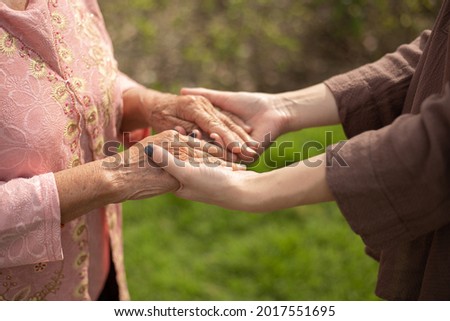 Hand of eldery woman with her caregiver at home. Home care or Elderly care concept.