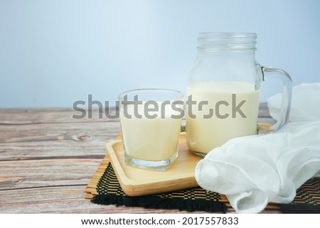 Soy milk, in glass bottles, and ready-to-drink glasses, placed in a wooden tray, made of rubber trees, with space, and Take a picture from the side
