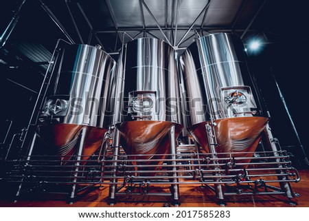 Rows of steel tanks for beer fermentation and maturation in a craft brewery Royalty-Free Stock Photo #2017585283