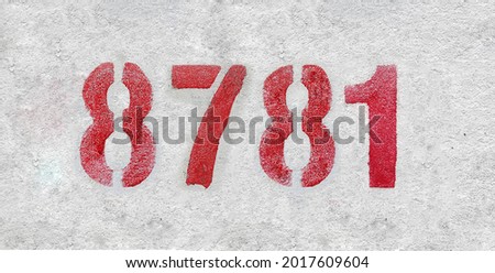 Red Number 8781 on the white wall. Spray paint. Number eight thousand seven hundred and eighty one.