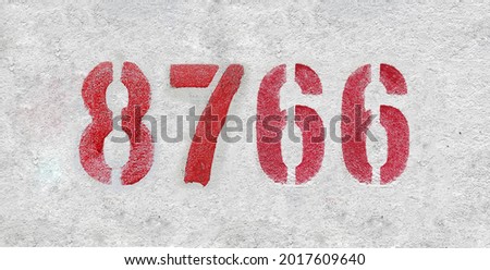 Red Number 8766 on the white wall. Spray paint. Number eight thousand seven hundred sixty-six.