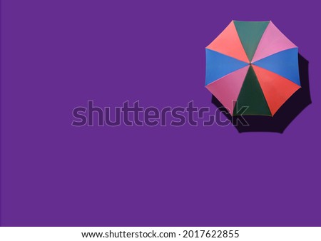Top view, Single rainbow umbrella isolated on purple background for stock photo or design, invesment, business, summer concept