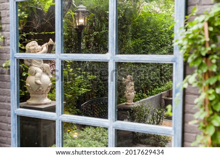 Reflecting in window from garden English design and green leaf 