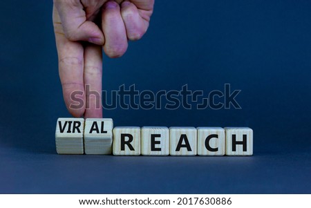 Viral reach symbol. Businessman turns wooden cubes and changes words 'reach' to 'viral reach'. Beautiful grey table, grey background, copy space. Business, viral reach concept.