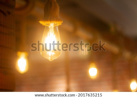 Vintage Light bulb, Lamp hanging with Blurred background at Coffee shop in india for decorate and background picture. selective focus.
