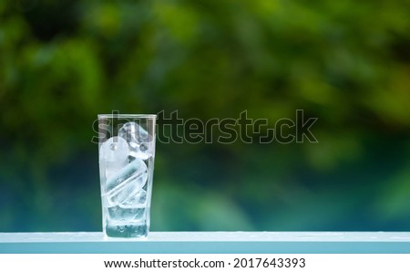 ice in glass on wood table  in outdoors garden blurred background