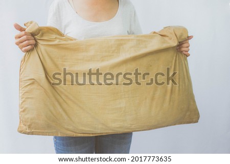 Woman holding a pillow with dirty stains, yellow stains, sweat stains. Cleaning concept.