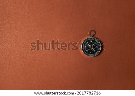 Compass on brown background. Concept signs symbols.