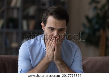 What to do. Worried nervous millennial man covering mouth with hands feeling fear panic attack having mental problems. Desperate scared man need psychological help can not see way out of life crisis Royalty-Free Stock Photo #2017793894