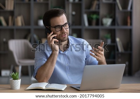 Counseling caller. Millennial man agent realtor work from home office sit by pc give professional advice to client by phone. Young businessman talk on cellphone discuss business project with colleague Royalty-Free Stock Photo #2017794005