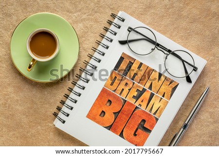 think and dream big motivational phrase -  word abstract in letterpress wood type in a notebook with coffee