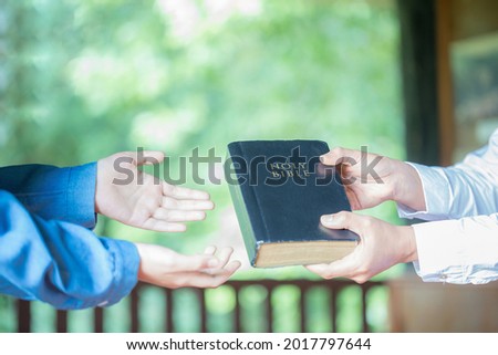 Woman hands giving Bible and evangelizing someone,Gospel Royalty-Free Stock Photo #2017797644