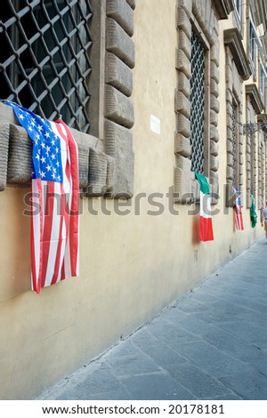 American and italian flag hanging from old building windows