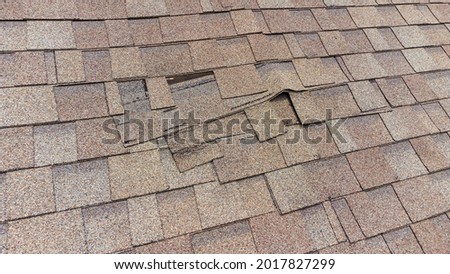 Roof Shingles damaged and in need of repair Royalty-Free Stock Photo #2017827299