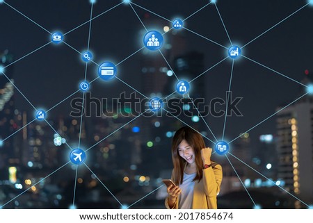 Asian businesswoman using smart mobile phone for Computer Network connection line between building with various of internet of thing icon in the financial district area, technology with career concept