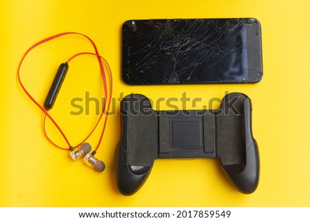 devices for online games have earphones, handle for playing mobile games. black with the shape of a game console isolated on a yellow background