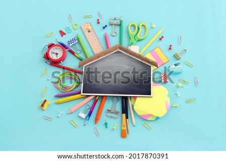 Back to school concept. Top view image of blackboard and student stationery over pastel blue background