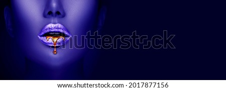 Lipstick dripping. Paint drips, lipgloss dripping from   lips, liquid Gold metallic paint drops on beautiful model silver girl's mouth, creative make-up. Beauty woman face makeup close up. Art.  Royalty-Free Stock Photo #2017877156