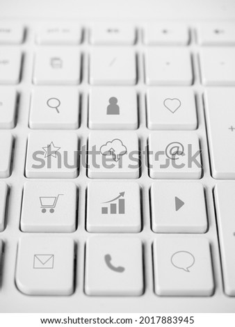 Business and economy icons on white clean buttons on computer keyboard, minimal style, vertical.