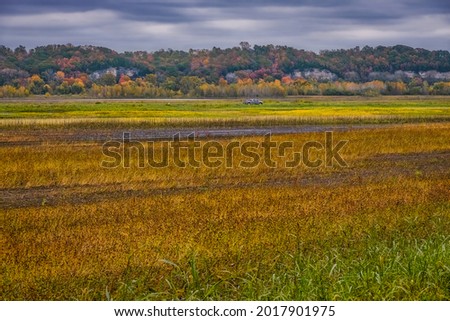 View of Missouri River floodplain in autumn; agricultural filed in foreground; Missouri River Bluffs in background