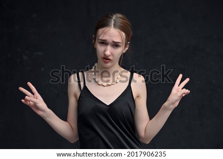Young caucasian woman model showing greeting fingers on black background