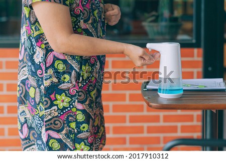 Automatic alcohol dispenser for cleaning hand to prevent the spreading of Coronavirus (Covid-19) on table before entrance to cafeteria. Healthcare concept. New normal lifestyle. Selective focus Royalty-Free Stock Photo #2017910312