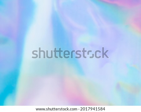 Beautiful holographic rainbow abstract background in pastel and neon color design. Real photography shot of holographic foil for creative project - design fashion, cover, book, printing. Copy space