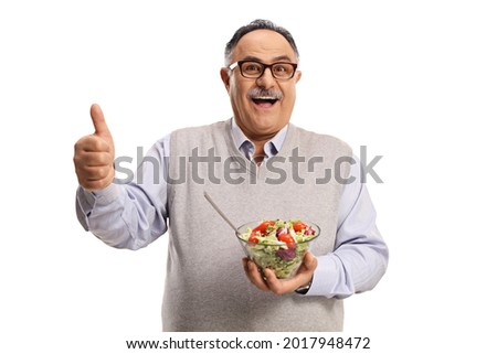 Cheerful mature man holding a healthy fresh salad in a bowl and showing thumbs up isolated on white background Royalty-Free Stock Photo #2017948472