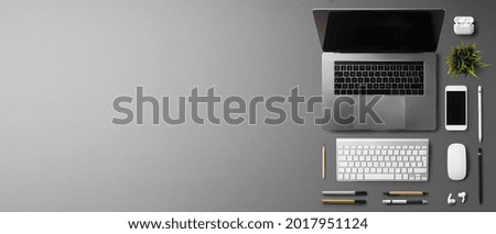 Flat lay top view office desk working space with laptop on gray background. Copy space.