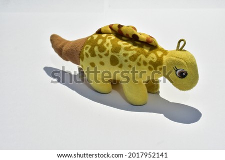 a stuffed or miniature dinosaur animal with a brown stegosaurus type
