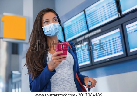 Travel vaccine passport woman tourist arriving at airport using mobile phone app for vaccination proof during coronavirus pandemic vacation. Asian girl in terminal. Royalty-Free Stock Photo #2017964186