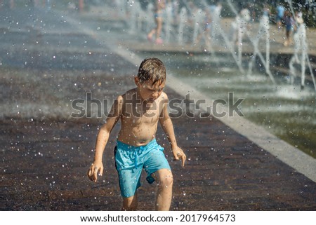  little boy running in splashing fountain in Saint petersburg, Russia. High quality photo