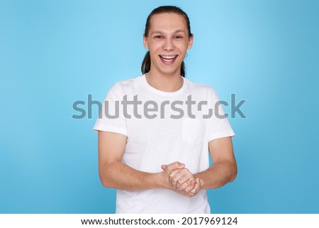 young handsome guy in t-shirt smiling isolated on blue background.
