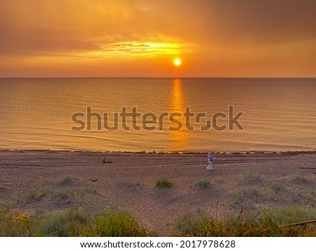 The couple walks along the sea in the golden hour. Colorful sunset at the Baltic Sea.