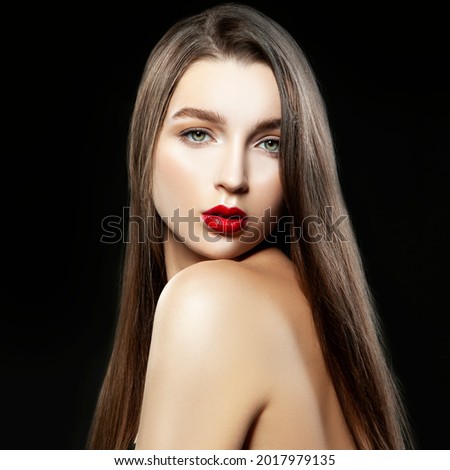 Beautiful girl model posing at studio with make-up, perfect skin, hair style over blak dark background