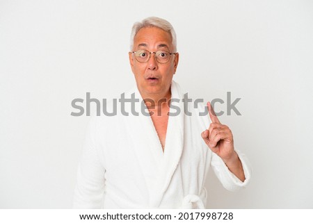 Senior american man wearing bathrobe isolated on white background having some great idea, concept of creativity.