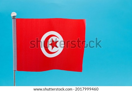 Tunisian flag waving on blue background.