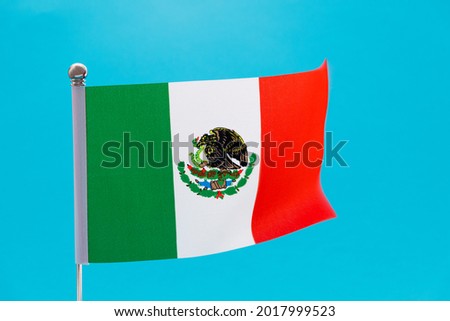 Mexican flag waving on blue background.