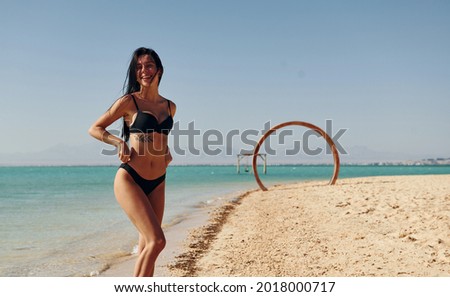 Beautiful young woman in bikini have vacation on the sea at sunny daytime.